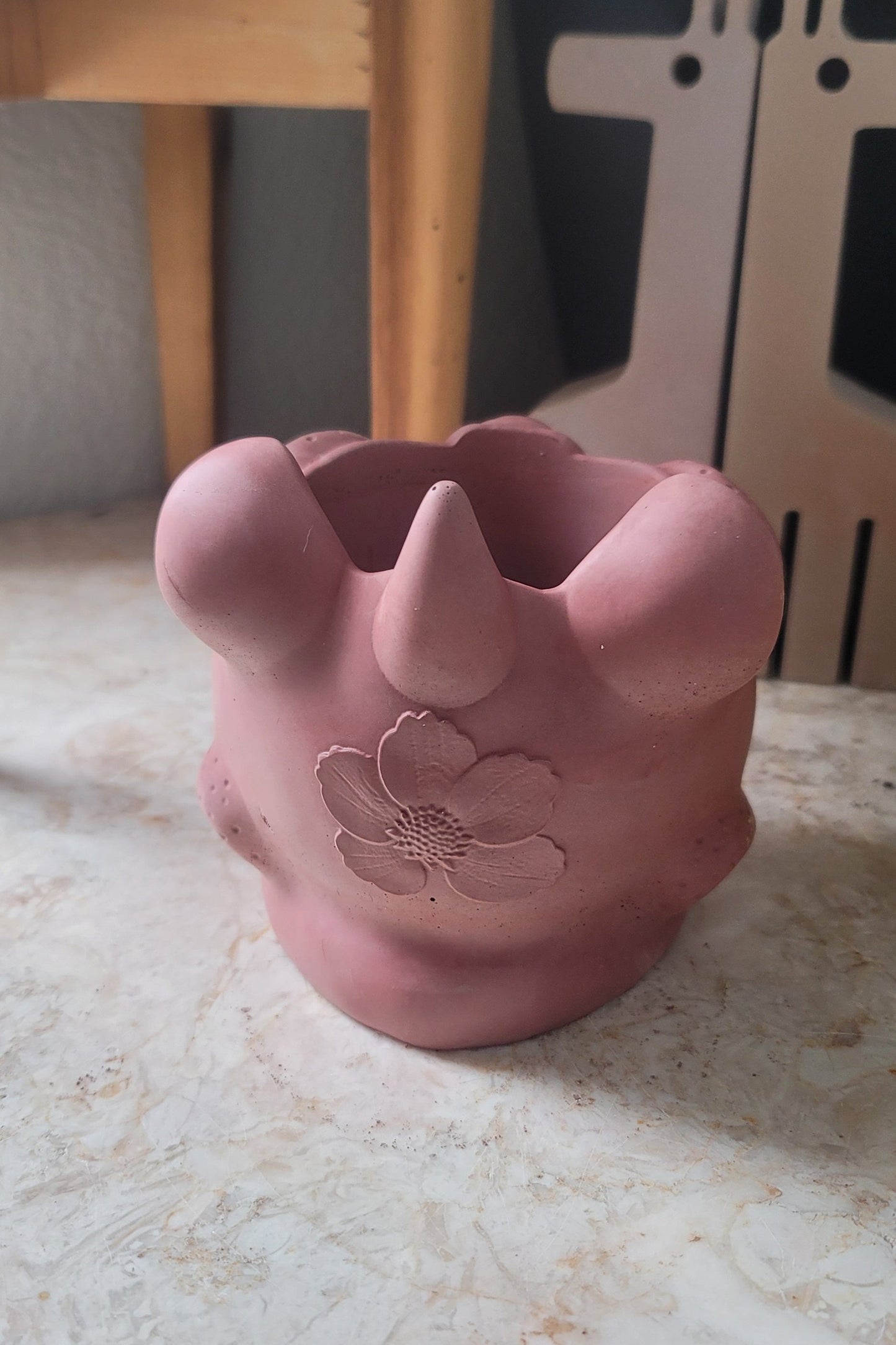 A back view of the lion head planter, featuring the intricate details of its mane and face, with Just Jinx'd special strawberry flower nestled inside. The vibrant, delicate flower adds a pop of texture, beautifully complementing the details of the planter.